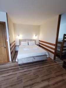 sypialnia z dużym łóżkiem i drewnianą podłogą w obiekcie Seosko domaćinstvo Kastratović w mieście Berane