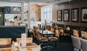 une salle à manger avec des tables et des chaises dans un restaurant dans l'établissement Clarion Collection Hotel Majoren, à Skövde