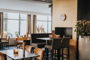 a restaurant with tables and chairs and a fireplace at Clarion Collection Hotel Majoren in Skövde