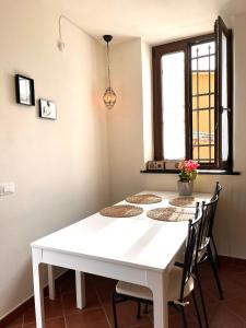 einen weißen Tisch mit Stühlen in einem Zimmer mit Fenster in der Unterkunft Casa Møjn in Lerici