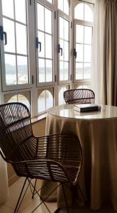 stół z 2 krzesłami i stół z oknami w obiekcie Hostal O Forno w mieście O Barqueiro