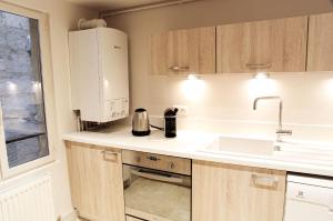 una pequeña cocina con fregadero y microondas en Condillac - Appartement 2 chambres avec ascenseur et Parking, en Burdeos