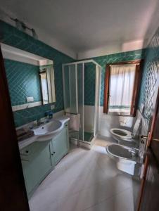 a bathroom with two sinks and two toilets at Villa Tiziana R1673 in Is Traias