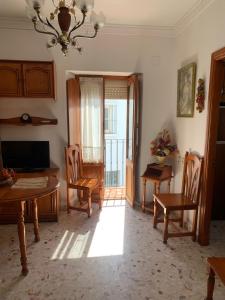 een woonkamer met een tafel en stoelen en een raam bij Casa Ana in Vejer de la Frontera