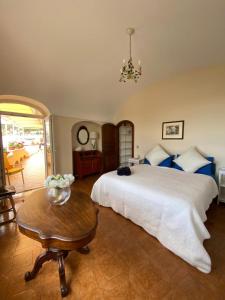a bedroom with a large white bed and a table at Sea View con terrazza e giardino in Capri