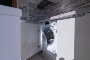Waschmaschine und Trockner in einer Waschküche in der Unterkunft Free beach residence-Bungalow 1253 a 50mt dalla spiaggia in Costa Rei