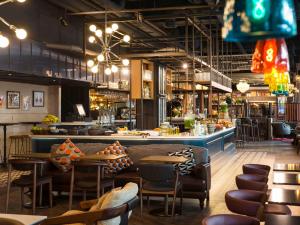 um restaurante com mesas e cadeiras e um bar em ibis Amsterdam Centre em Amsterdã