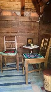 2 Stühle und ein Tisch in einem Blockhaus in der Unterkunft Etno Konačište-Restoran Stara Čivija in Bosanska Dubica
