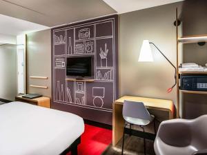 Pokój z łóżkiem i biurkiem oraz pokój z łóżkiem w obiekcie ibis Amsterdam Centre w Amsterdamie