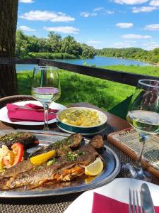 een tafel met een bord eten en een glas wijn bij Etno Konačište-Restoran Stara Čivija in Bosanska Dubica