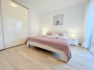 um quarto com uma cama num quarto branco em Palit Hills Superior Apartments em Rab