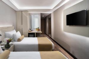 Habitación de hotel con 2 camas y TV de pantalla plana. en Pianoforte by Febor Hotels&Spa, en Estambul