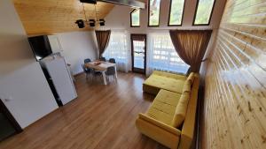 a living room with a couch and a table at Catunul din Podei Vila Sophia in Dragoslavele