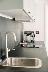 - un comptoir de cuisine avec évier en acier inoxydable dans l'établissement Le Saint Amans, à Rodez