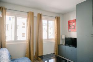 - une chambre avec un lit, une télévision et des fenêtres dans l'établissement Le Saint Amans, à Rodez