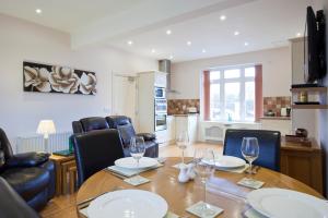 ein Esszimmer mit einem Tisch und Stühlen sowie eine Küche in der Unterkunft Premier Apartments in Caister-on-Sea