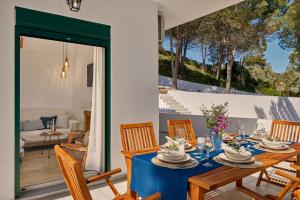 una sala da pranzo con tavolo e sedie di Vera Villa - Brand New Seafront Villa! a Alykes