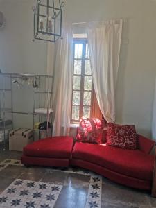 a red couch in a living room with a window at rincones con encanto 