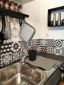 una cocina con fregadero y algunos azulejos en la pared en Fadil, en Valenciennes