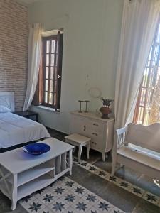 a bedroom with a bed and a table and some windows at rincones con encanto 