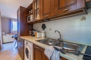 a kitchen with a sink and a washing machine at Incanto Apartment by Wonderful Italy in Bellagio +23 photos