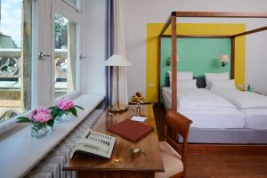 a hotel room with a bed and a desk with a desk at Hotel Schloss Eckberg in Dresden