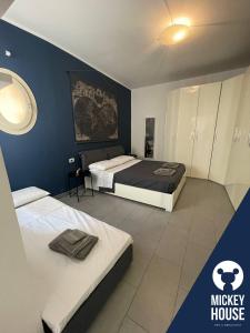 sypialnia z 2 łóżkami i niebieską ścianą w obiekcie Mickey House - Casa in centro vicino all’autodromo w mieście Imola