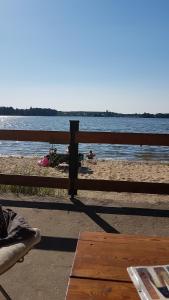 a fence on a beach with people on the beach at Waldhaus Wiesengrund in Schwielochsee