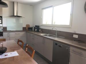 a kitchen with a table and a sink and a window at Gite la Garrigue in Ferrals-lès-Corbières