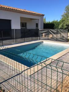 a swimming pool in front of a house at Gite la Garrigue in Ferrals-lès-Corbières