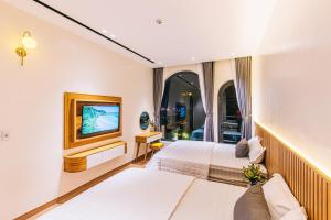 a hotel room with two beds and a tv at Siêu Biệt Thự Ven Biển MICAE Sầm Sơn in Sầm Sơn