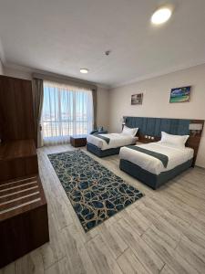 um quarto de hotel com duas camas e um sofá em SEAVIEW HOTEL em Umm Lajj