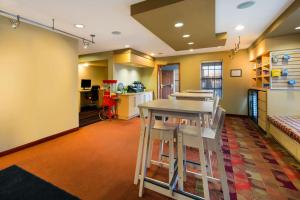 a kitchen with a table and chairs in a room at Sonesta Simply Suites Detroit Novi in Novi