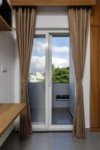 a sliding glass door with curtains in a room at Home Awaits 357 in Bengaluru