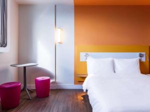 a hotel room with a bed and a stool at ibis budget Pindamonhangaba in Pindamonhangaba