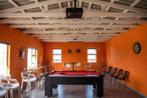 a room with a ping pong table and chairs at 36 Emanzini (Holiday home lake view) in Denysville