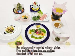 ein weißer Tisch mit Teller mit Lebensmitteln drauf in der Unterkunft 阿寺温泉 フォレスパ木曽あてら荘 in Okuwa
