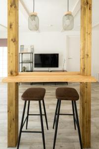 a kitchen with a wooden table with two bar stools at Apartamento ALMA con terreno privado y parking compartido - a 800m de Playa Poniente in Benidorm