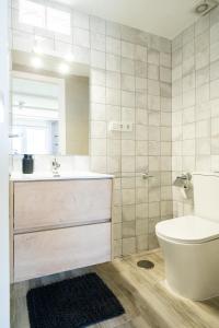 a bathroom with a sink and a toilet and a mirror at Apartamento ALMA con terreno privado y parking compartido - a 800m de Playa Poniente in Benidorm