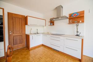 una cucina con armadietti bianchi e porta in legno di Apartments Vila Lena at Aqualuna a Podcetrtek