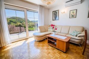 un soggiorno con divano e tavolo di Apartments Vila Lena at Aqualuna a Podcetrtek