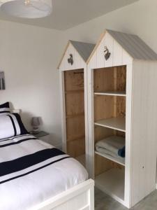 um quarto com uma cama e uma cabina de madeira com prateleiras em Gite avec piscine privative em LʼAiguillon-sur-Vie