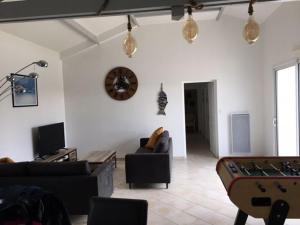 a living room with couches and a pool table at Gite avec piscine privative in LʼAiguillon-sur-Vie