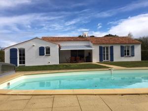 ein Haus mit einem Pool vor einem Haus in der Unterkunft Gite avec piscine privative in LʼAiguillon-sur-Vie