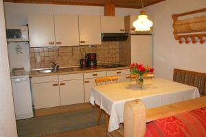 a kitchen with a table with a vase of flowers on it at Ferienwohnungen Foidlhof in Hochfilzen
