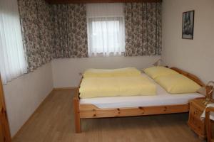 a bedroom with a bed and two windows at Ferienwohnungen Foidlhof in Hochfilzen