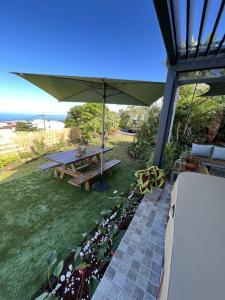 勒唐蓬的住宿－Villa, Lossy，一张带雨伞和一些植物的野餐桌