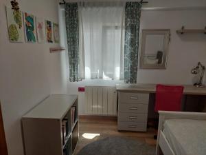 a small bedroom with a desk and a window at Family apartment Andrea in Alaquas