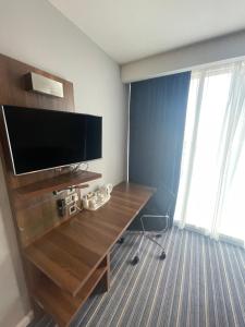 a room with a television and a desk with a chair at Holiday Inn Express Manchester City Centre, an IHG Hotel in Manchester