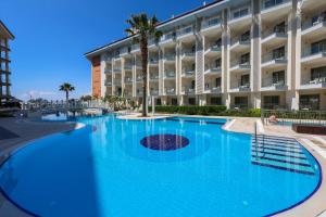 een groot zwembad voor een groot gebouw bij Ramada Hotel & Suites by Wyndham Kusadasi in Kuşadası